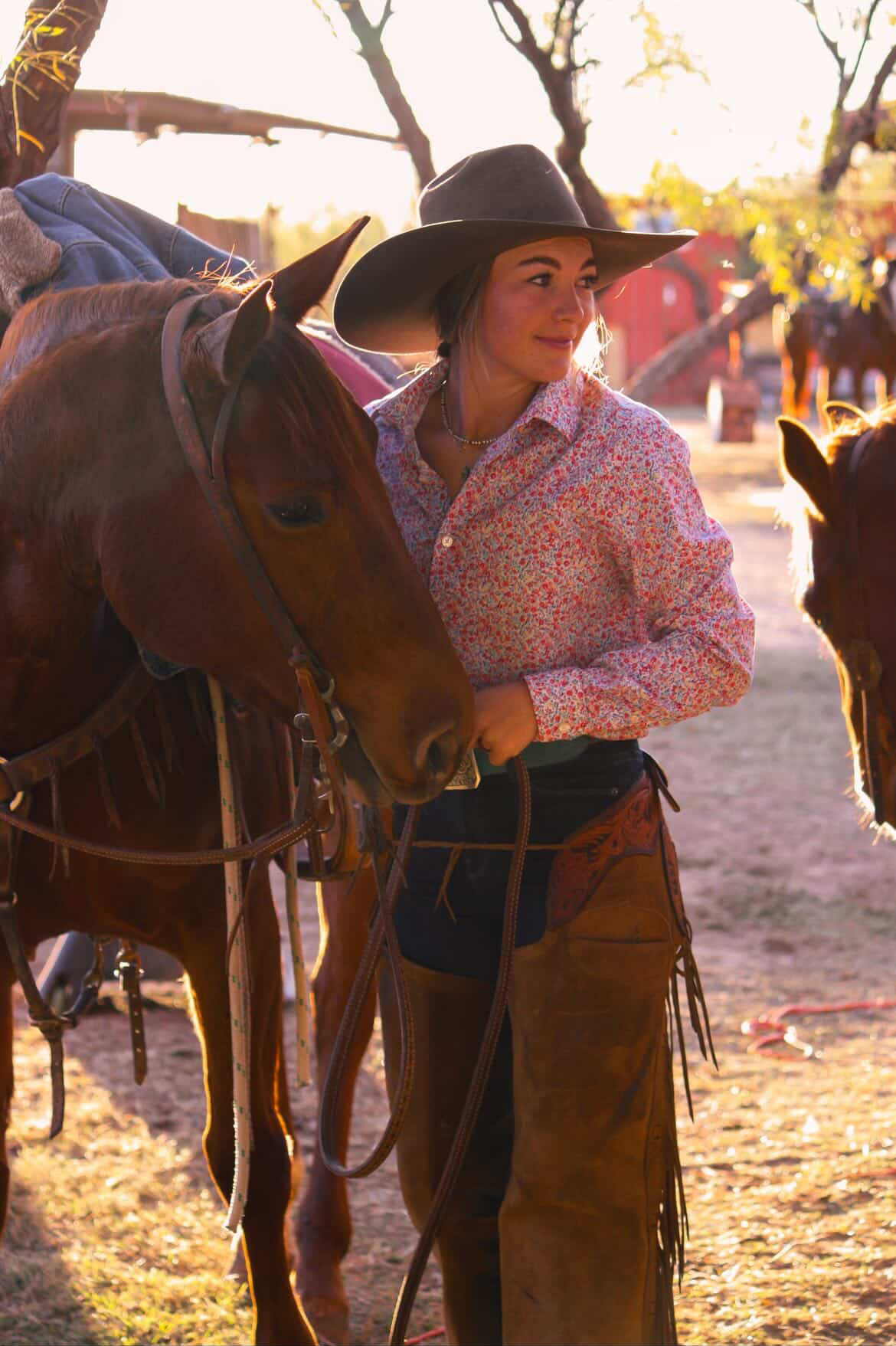 Family sitting on a wooden ranch fence at golden hour in West Texas