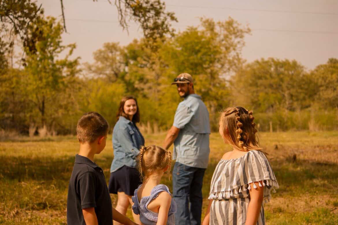 Family walking together across a field in golden light